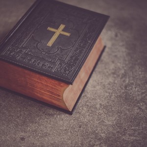 An open Bible with a gold cross on its cover